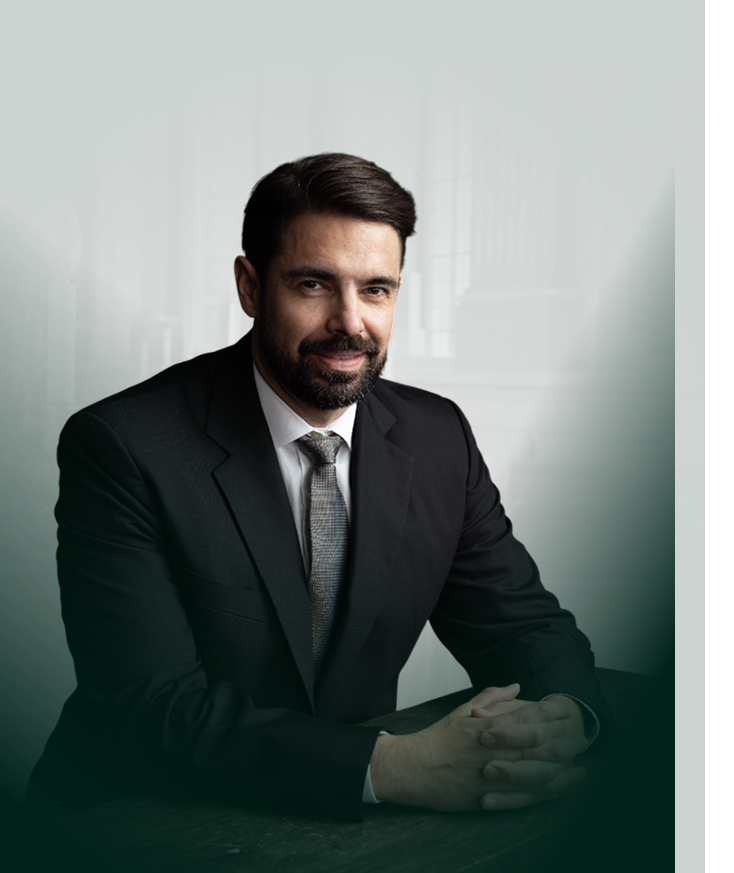 1. Professional businessman in a formal suit sitting at a desk in a sophisticated office setting.