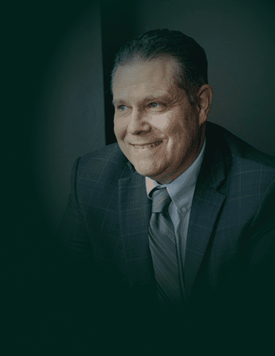 Frank McElroy, a distinguished legal expert, smiling confidently in a professional setting.